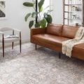 Skye Grey Apricot Rug styled in living room under brown leather sofa and beige chair