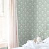 Wallpaper featured in bright bedroom corner with natural light, beige curtains, and white bedding