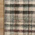 Close-up of Humphrey Forest rug corner on hardwood floor showing printed plaid and beige edging.