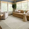 Beau Brown / Ivory Pillow styled on a tan checkered sofa in a sunlit living room with light blue valances
