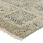 High angle close-up of the fringed edge corner showing intricate hand-knotting and soft colors