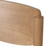 Close-up of wooden backrest’s natural grain and subtle curved details