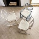 Angled top-down view showing curves of rocking rails and cushioned seats in three color variations on hardwood floor
