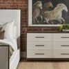 Tailor Bed styled in bedroom with white dresser and brick wall, partial bed side visible with pillows