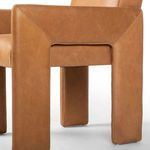 Close-up of leather panel and detailed stitching on outer arm of Amur Dining Armchair