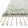 Close-up side view showing plush shaggy pile height and twisted fringe detail on neutral backing of the Hygge Grey Mist Rug