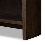 Close-up of bottom rounded corner and base molding of Lockhart Bookcase with dark oak finish