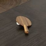 Close-up on wooden Ping Pong paddles and ball atop dark metal tabletop