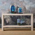 Console table styled with blue butterfly decor and ceramic bunny sculpture on shelf