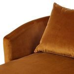 Close-up detail of pillow and armrest seam in rich burnt orange velvet fabric