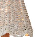 Close-up detail of the scalloped edge and woven pattern on the illuminated whitewashed seagrass shade