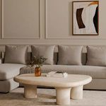 Thomas sectional in neutral living room styled with round stone coffee table and wall art