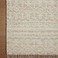Rug corner on wood floor highlighting woven pattern and fringe against flooring