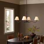 Darcia Chandelier illuminating a browns and neutrals themed dining space with natural light from window