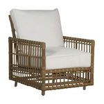Outdoor woven lounge chair with natural brown frame and white cushioned seat and back