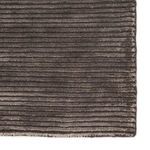 close-up on dark gray rug corner emphasizing soft wool-viscose texture and ridged linear pattern