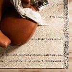 Close-up of corner with black border detail under leather chair on natural wood floor