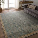 Rug placed in living room with grey upholstered sofa and wood flooring visible