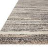 Angled view showing the textured pile height and edge of the beige Theory Mist rug
