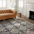 Jocelyn Navy rug displayed in a bright room with tan leather tufted sofa and fireplace