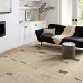 Bowery Slate taupe rug styled in bright modern living room with black sofa and coffee table
