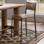 Kayne leather counter stool styled in a modern kitchen setting near wooden table and large window