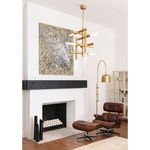 Cass Chandelier hanging in modern living room above lounge chair with abstract wall art and gold arc lamp