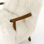 Tapered drifted oak leg emerging from thick cream-colored Mogolian fur cushion corner