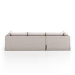 Minimalist straight back capture emphasizing slipcover folds and sectional's clean silhouette