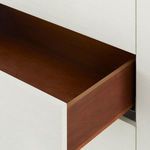 Interior of an open drawer showing reddish-brown wood interior contrasting with white exterior