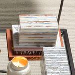 Mother of pearl decorative box shown from above on stacked books with candle and silver mosaic box nearby