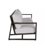 Side profile of sofa showing dark geometric aluminum frame and cushioned seat and back