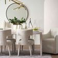 Close-up dining room view focusing on Avaline Table with beige chairs, decor, and gold chandelier