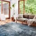 Samra Charcoal Sky Rug styled in modern room with wood-framed windows, sofa, and plants
