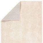 Back side of cream geometric rug flipped at corner showing white and gray striped rug backing