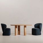 Two Larson rolling dining chairs positioned around a wood table in a minimalist white room