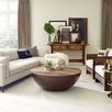 Coffee table styled with tray and decor in living room with white sectional sofa and wall with framed art