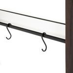 Close-up of black metal bar with two S-shaped hooks against beveled mirror
