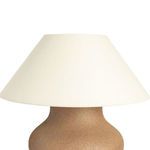 Angled close-up of lamp showing top half of ceramic base and underside of fabric shade