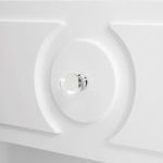 Detailed close-up of round clear glass drawer pull with chrome base on recessed circular panel