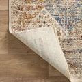 Corner flipped up exposing woven backing of the Sorrento rug on hardwood floor