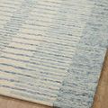 Close angled perspective of Denim Rug corner with focused view on blue stripe texture and finished border