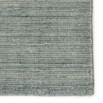 Macro view of the rug surface highlighting detailed woven texture in blended blue and gray fibers