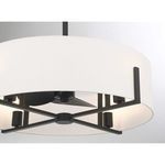 Close-up of the fan’s matte black prongs and the structure underneath the white shade