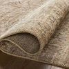 Close-up of the Heritage Ivory/Natural rug rolled to reveal texture and backing
