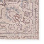 Close-up of rug's beige and blue medallion pattern emphasizing detailed woven texture.