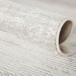 Rolled edge close-up of Paxton rug showing plush texture and intricate abstract carving in gray and ivory