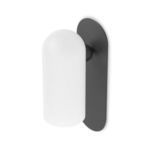 Angled view of Odyssey sconce showing curved matte white glass and elongated black gunmetal backing
