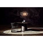 Styled dark room setting with single chair and pendant light casting shadows around table