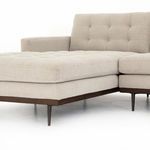 Tufted button detailing on chaise cushion with conical wooden legs in dark finish